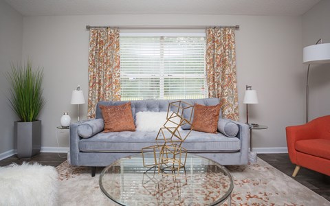 a living room with a couch and a table and curtains